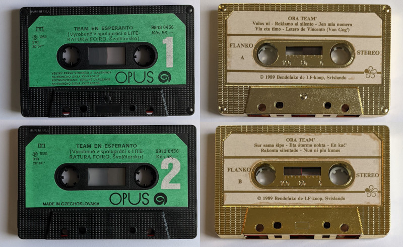The front and back sides of two cassettes: Team en Esperanto (black shell, green labels) and Ora Team' (gold shell, white labels)